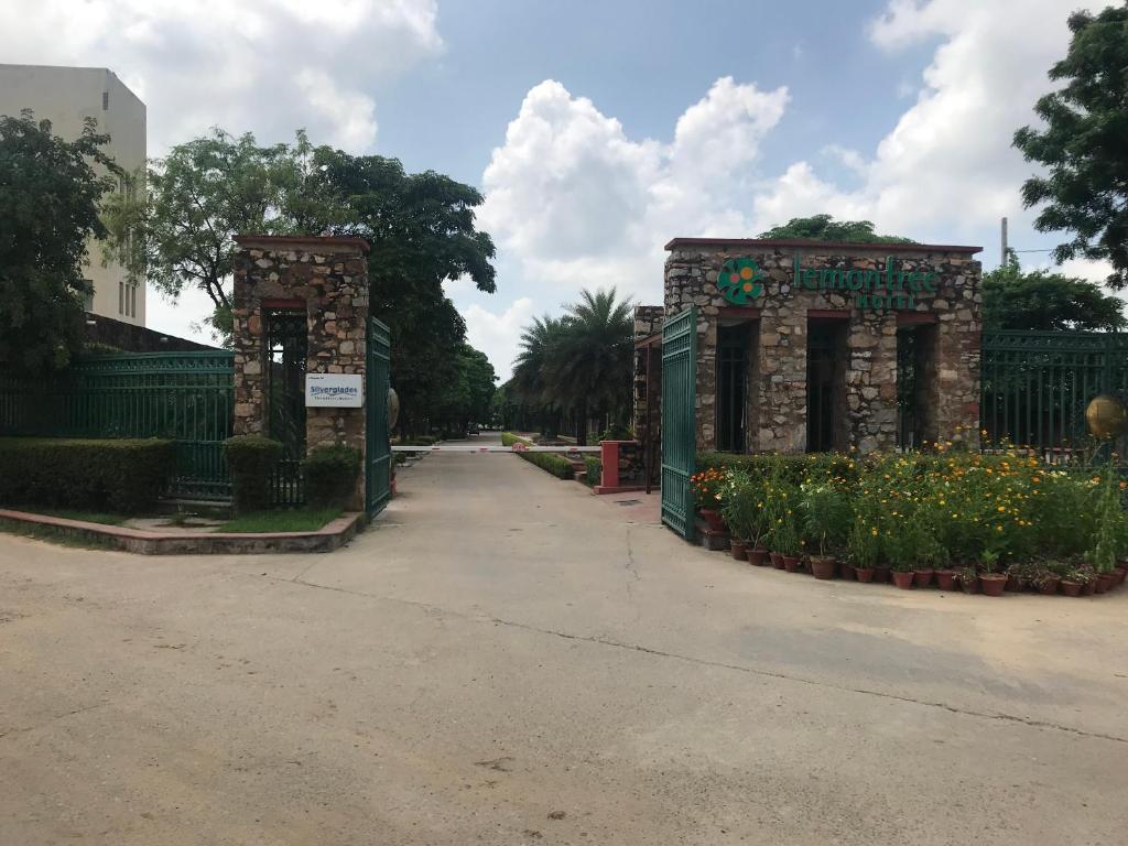 pusta ulica z bramą i kwiatami w obiekcie Premium Apartment in Tarudhan Valley Golf Resort w mieście Manesar