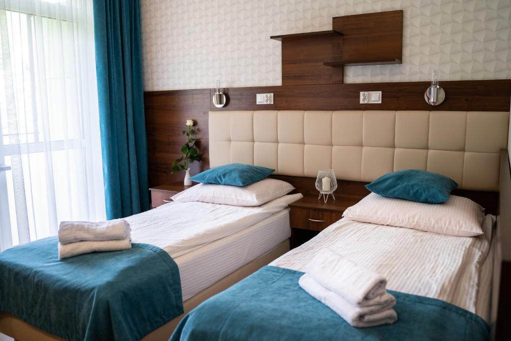 sypialnia z 2 łóżkami i oknem w obiekcie Centrum Promocji Zdrowia Sanvit w Iwoniczu-Zdroju