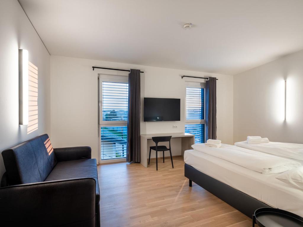 una camera con letto, sedia e scrivania di Hotel AT HOME - late arrival self check in a Graz