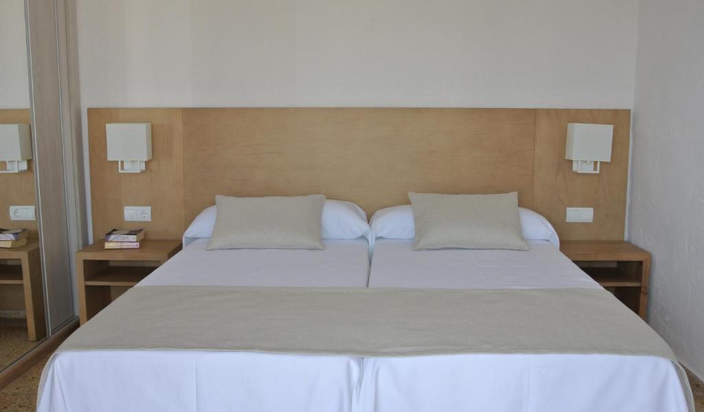 sypialnia z dużym łóżkiem i dwiema poduszkami w obiekcie Apartamentos El Moro w mieście San Antonio