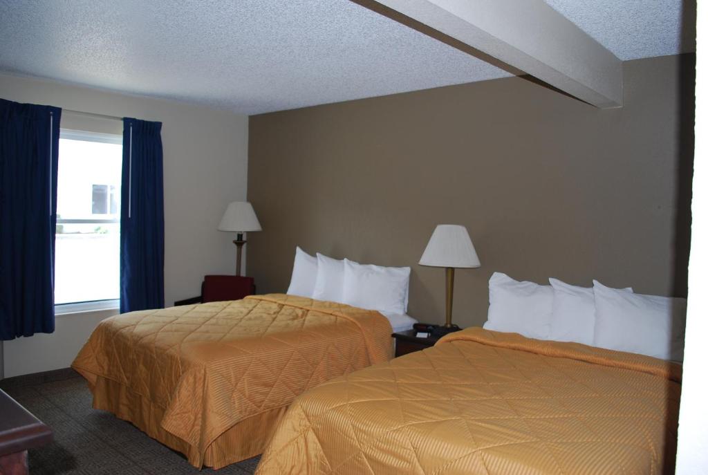 a hotel room with two beds and a window at Clinton Inn & Suites in Port Clinton
