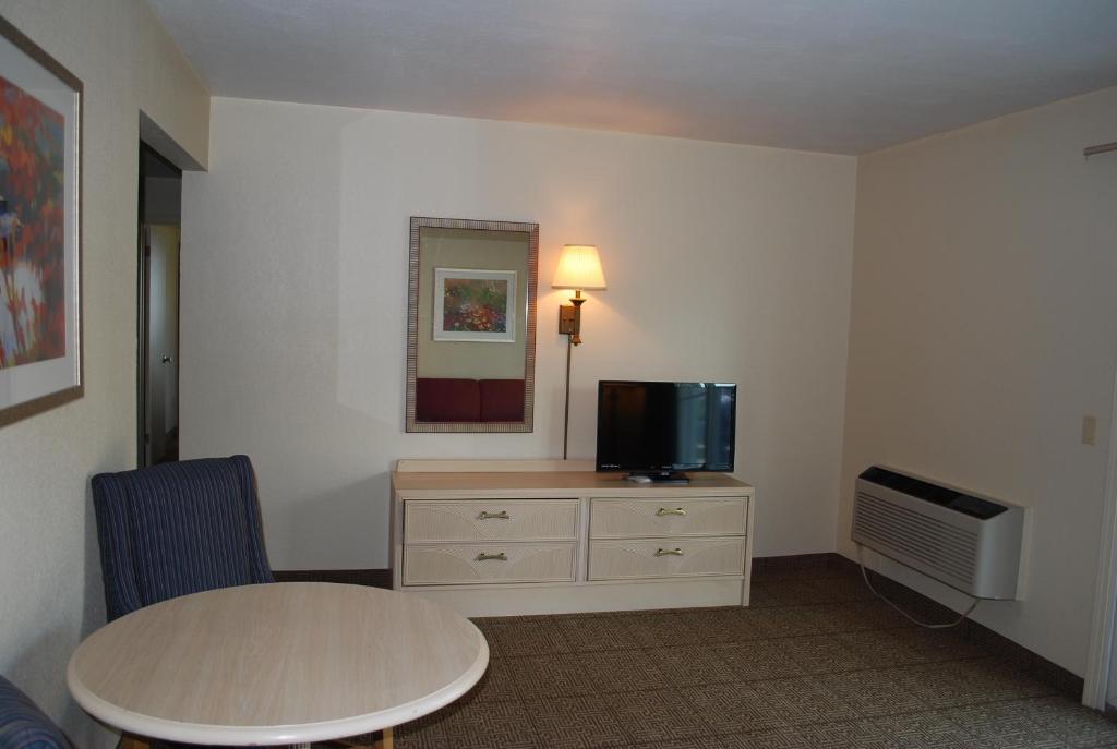 a room with a table and a tv on a dresser at Clinton Inn & Suites in Port Clinton