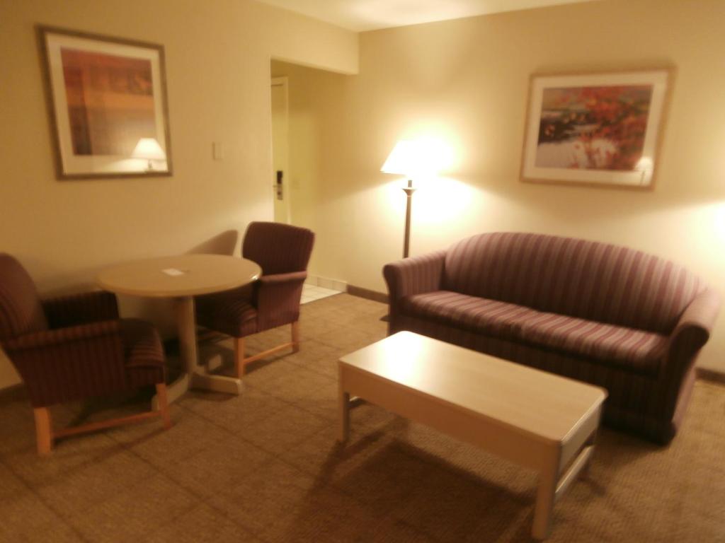 a living room with a couch and chairs and a table at Clinton Inn & Suites in Port Clinton