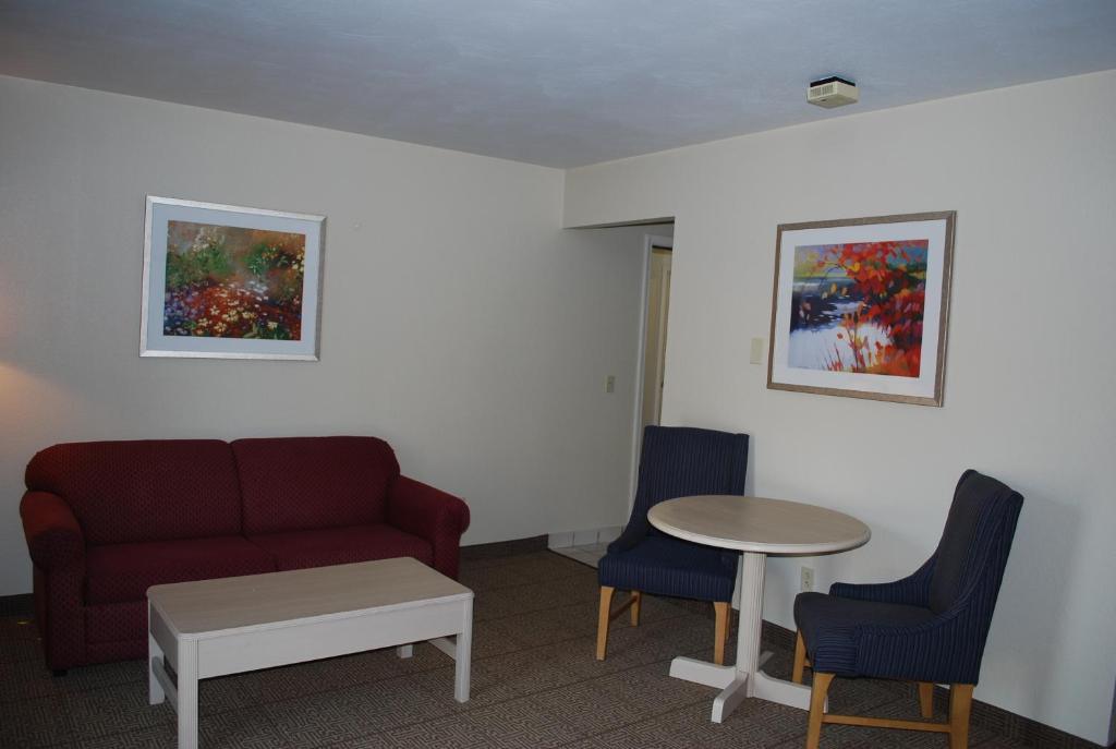 a living room with a couch and a table and chairs at Clinton Inn & Suites in Port Clinton