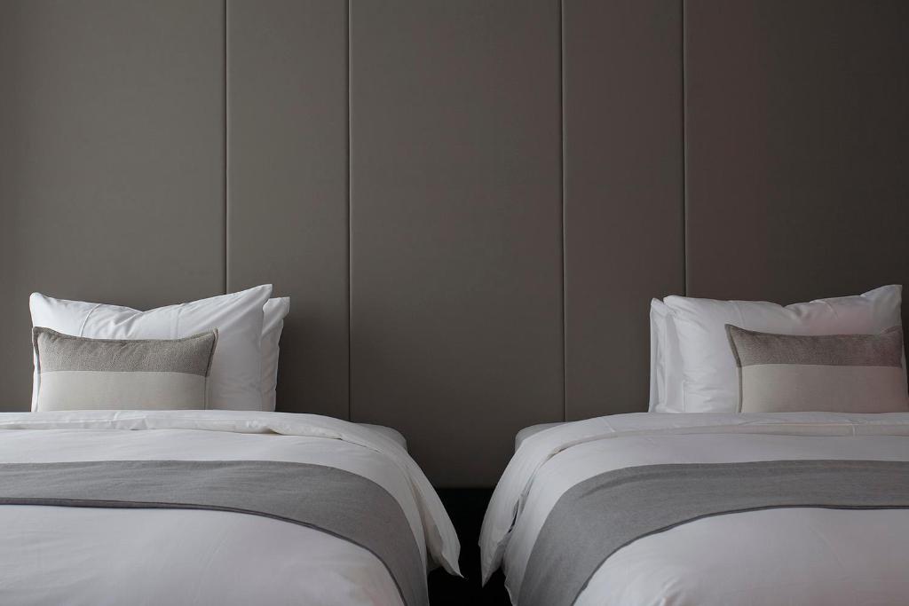 two beds sitting next to each other in a room at Manho Hotel in Taichung