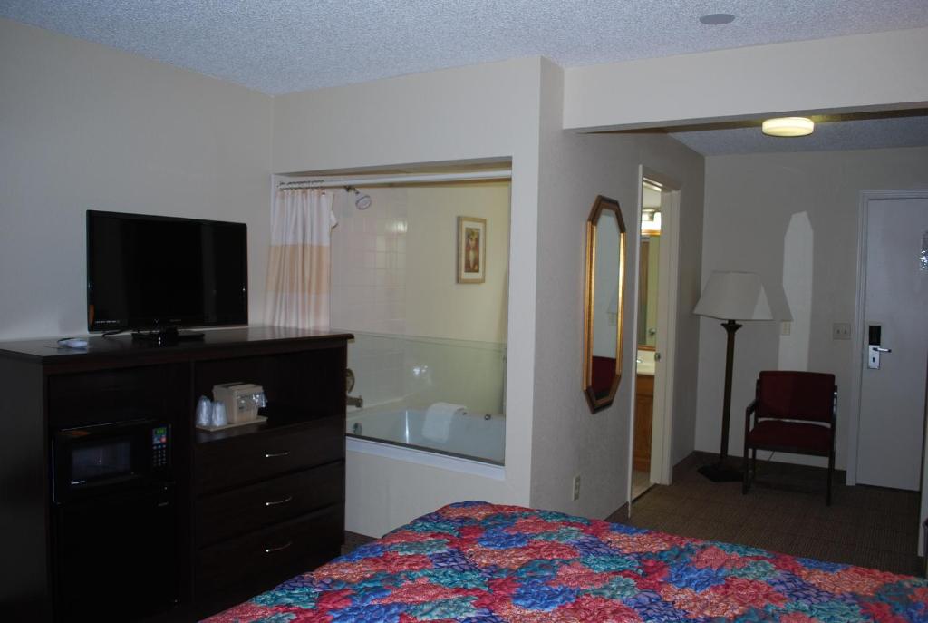 a bedroom with a bed and a dresser and a television at Clinton Inn & Suites in Port Clinton