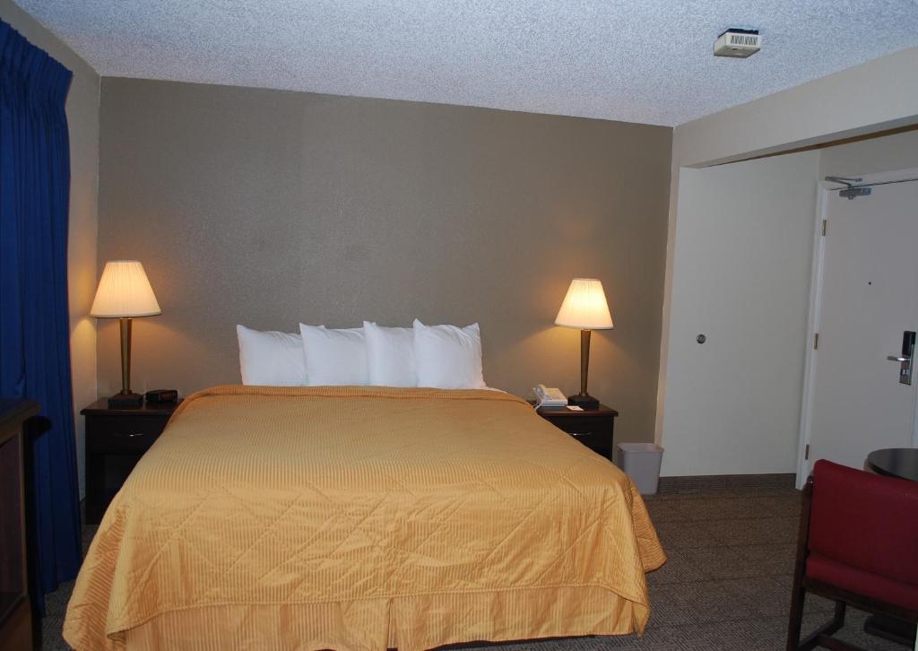 a hotel room with a bed and two lamps at Clinton Inn & Suites in Port Clinton