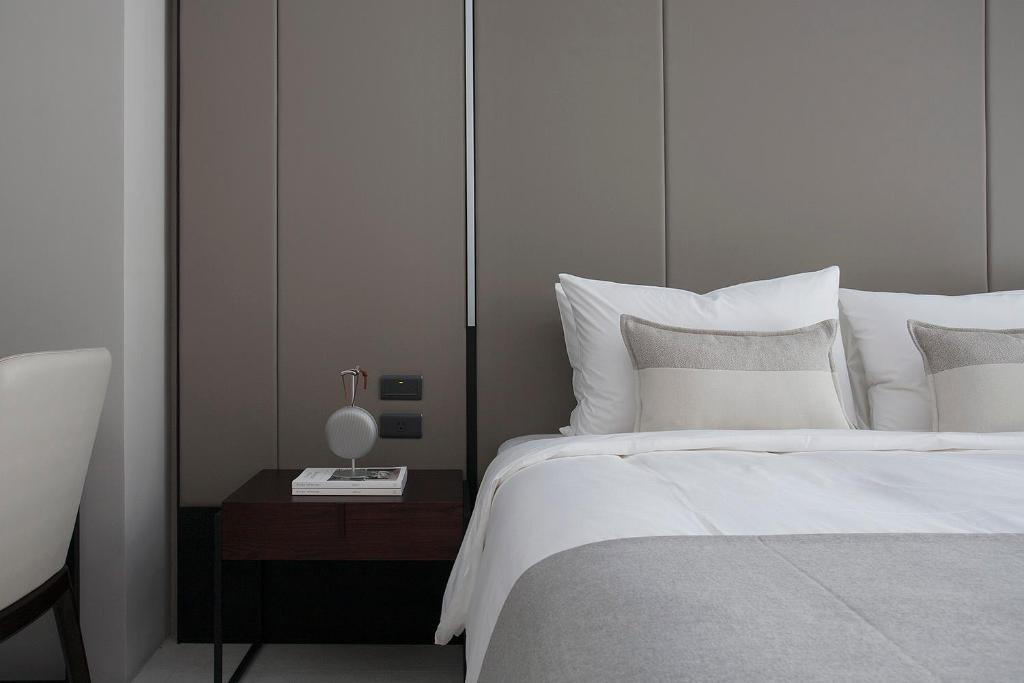 a bedroom with a white bed and a table with a lamp at Manho Hotel in Taichung