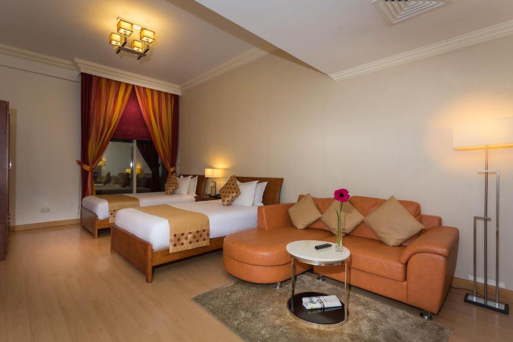 a hotel room with a bed and a couch at Al Safir Tower - Residence in Juffair