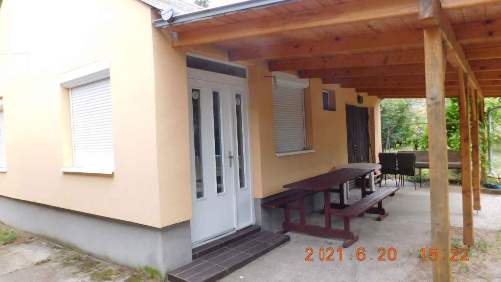 a house with a porch and a picnic table on a patio at Holiday home in Balatonmariafürdo 26831 in Balatonmáriafürdő