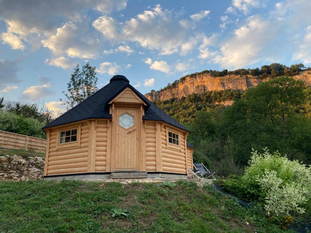 eine kleine Holzhütte mit einer Uhr drauf in der Unterkunft Aux Kotas Finland'Ain in Izieu