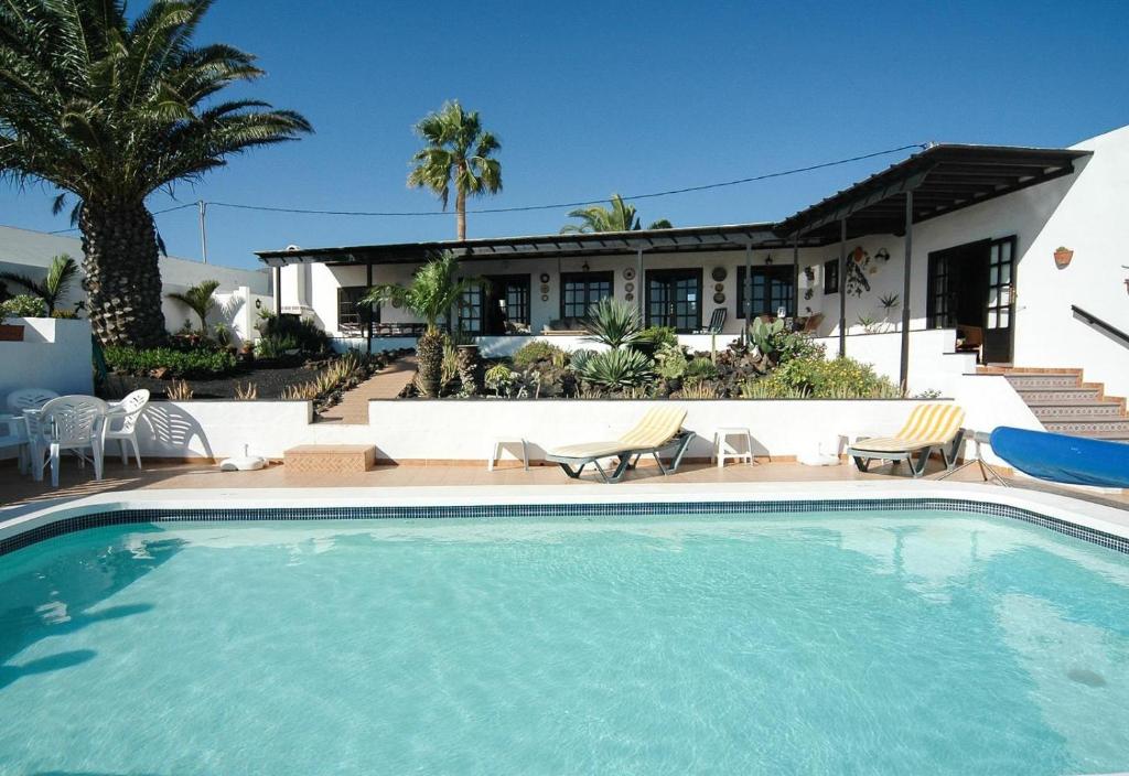 a swimming pool in front of a house at Finca el Volcan in Mácher