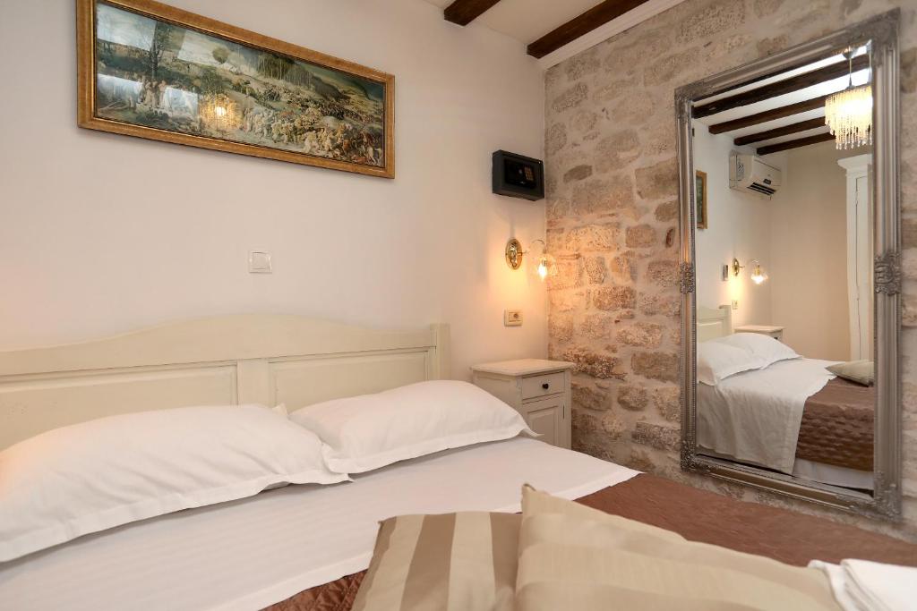 a hotel room with a bed and a mirror at Villa Carrara in Trogir