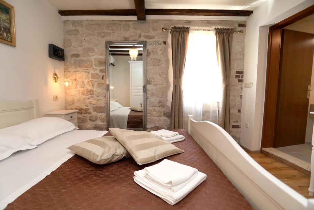 ein Schlafzimmer mit einem großen Bett und Handtüchern auf dem Boden in der Unterkunft Villa Carrara in Trogir