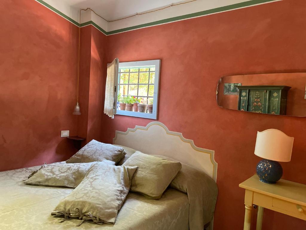 Dormitorio rojo con cama y ventana en Casina Morgana B&B, en Novafeltria