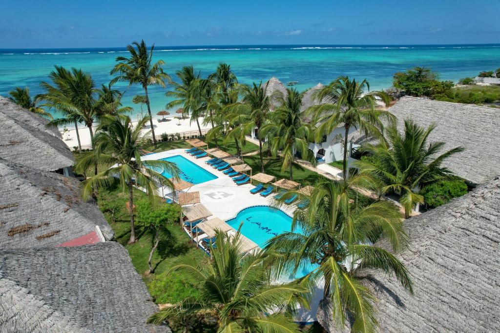 een luchtzicht op een resort met palmbomen en de oceaan bij Nest Style Beach Hotel Zanzibar in Makunduchi