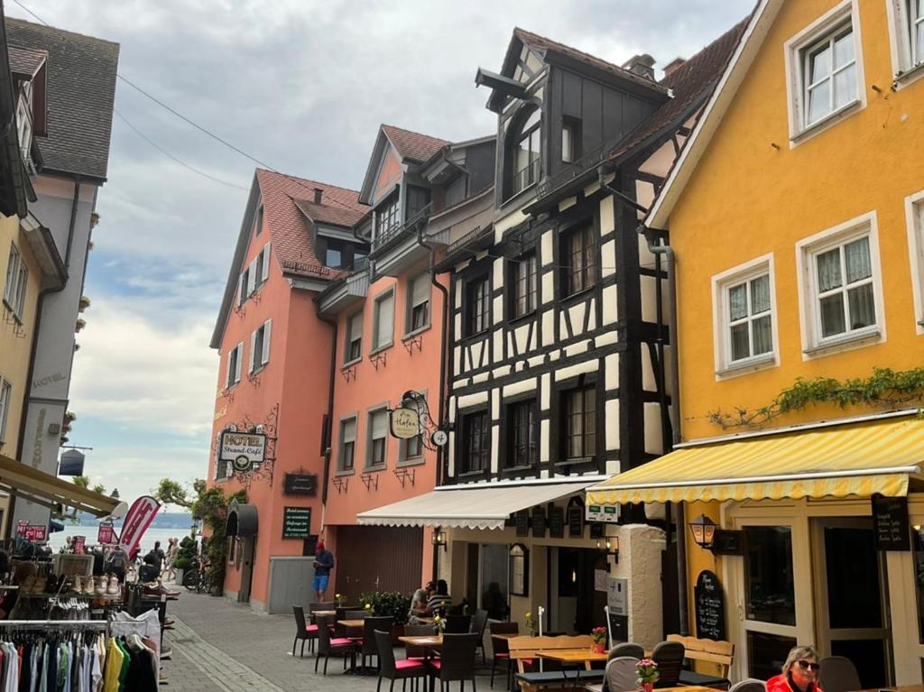 a group of buildings on a street with tables and chairs at Gästehaus AM HAFEN in Meersburg
