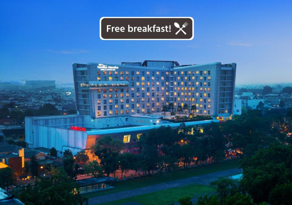 a large building with a free breakfast sign on it at Santika Premiere Dyandra Hotel & Convention - Medan in Medan