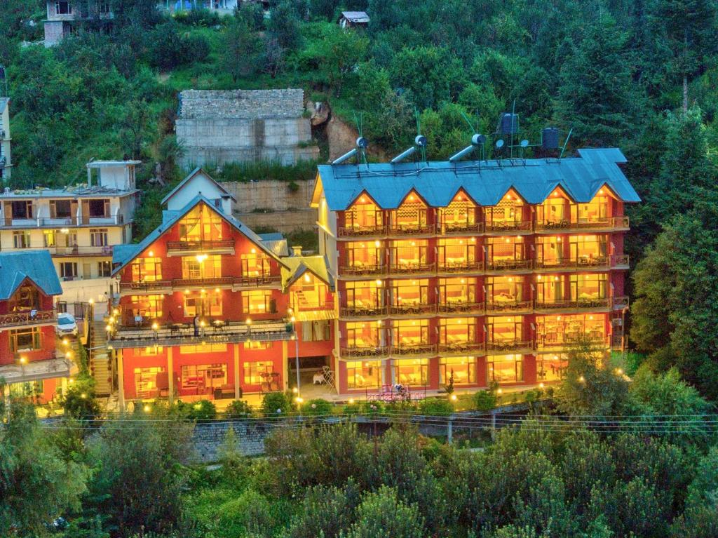 a large building with its lights on at The Holiday Resorts and Cottages in Manāli