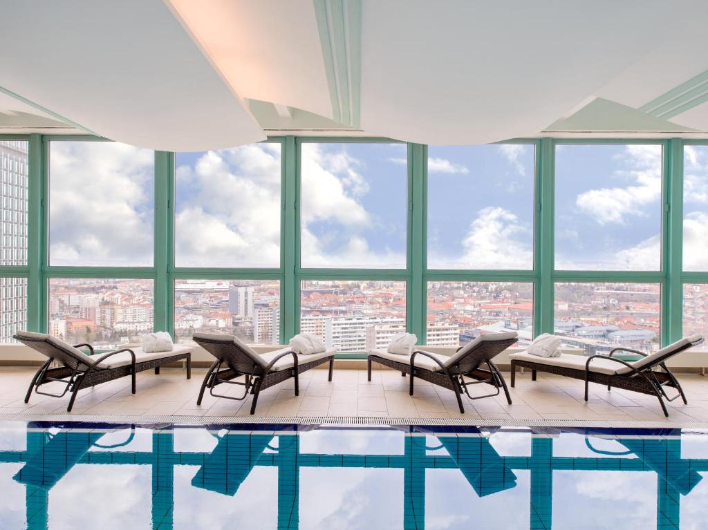 a pool with chairs and a view of a city at Panorama Hotel Prague in Prague