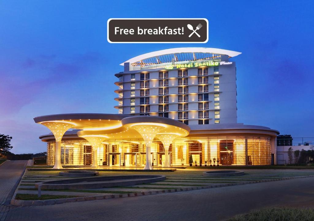 un edificio de hotel con un cartel que lee desayuno gratis en Hotel Santika Premiere Kota Harapan Indah, en Bekasi