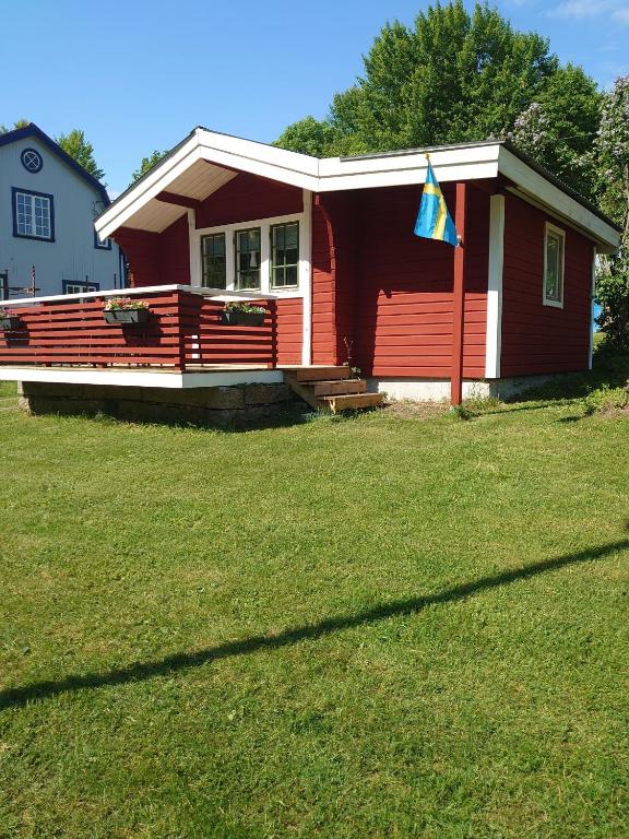 a red house with a flag in front of it at Natursköna Gysinge in Österfärnebo