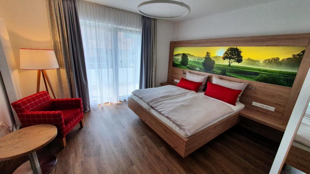 a hotel room with a bed and a red chair at Der Adler in Lauchringen
