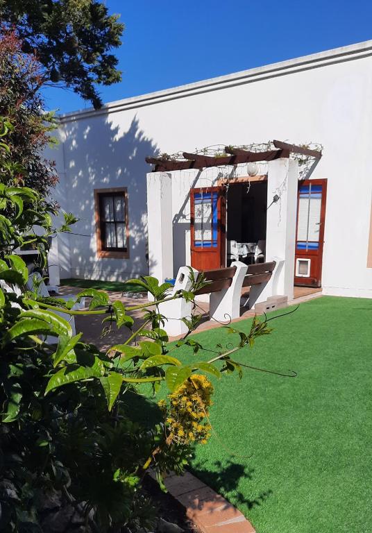 a white house with a yard with green grass at Ons Fontein in Langebaan
