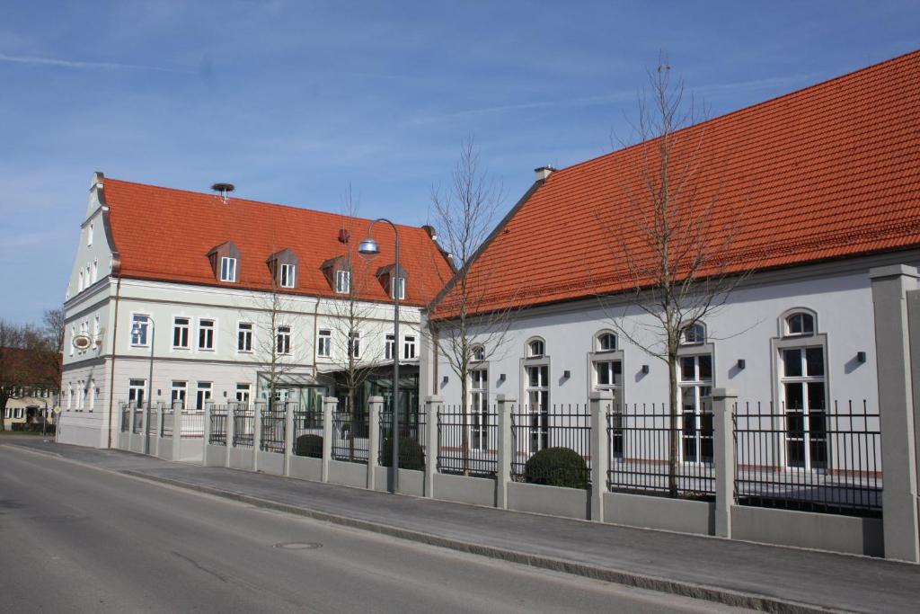 two white buildings with red roofs on a street at Alte Brauerei Mertingen in Mertingen