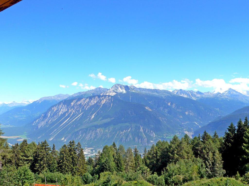 a view of a mountain range with trees in the foreground at Apartment Les Mischabels-1 by Interhome in Crans-Montana