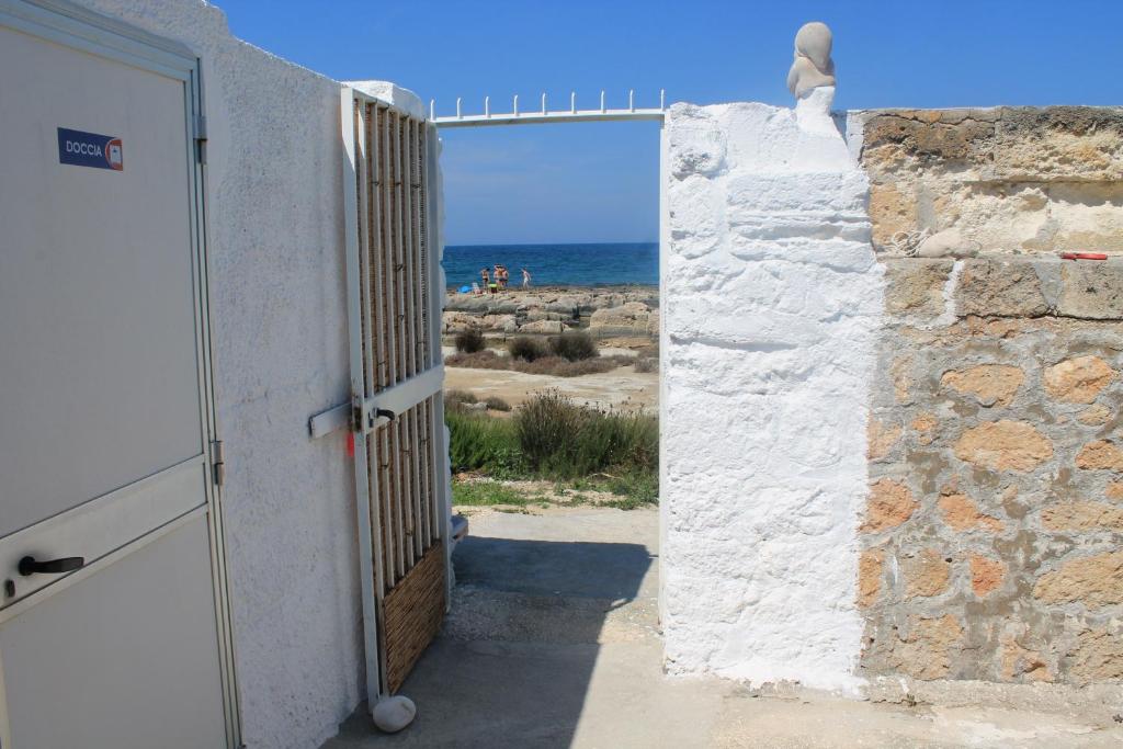 an open door to a building with a view of the ocean at Ville Alba & Azzurra in Polignano a Mare