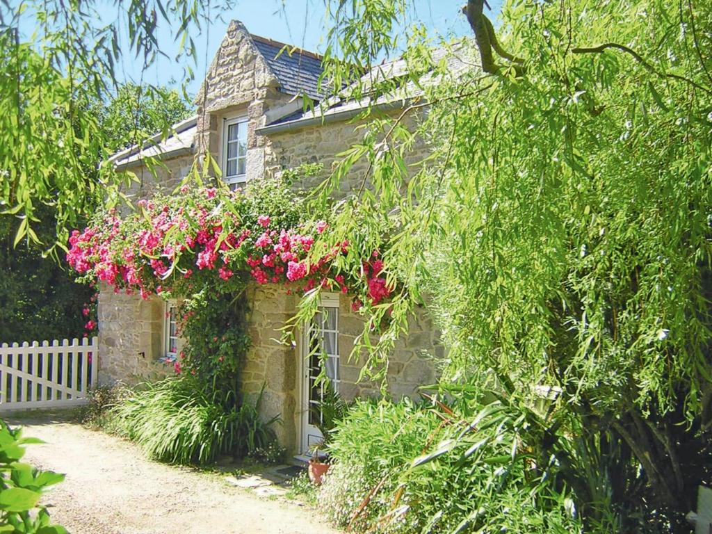 a stone house with flowers on the side of it at Holiday Home Keranna - LPM102 by Interhome in Lampaul-Ploudalmézeau