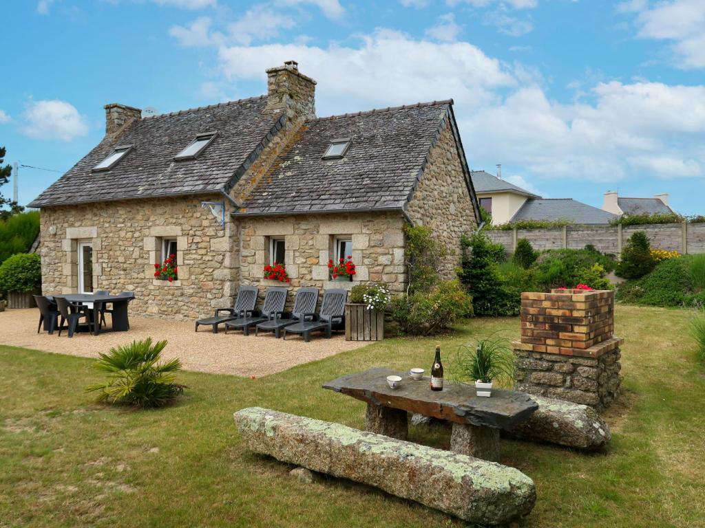 GuissényにあるHoliday Home Ty Coz - GUI113 by Interhomeの庭にテーブルと椅子を配置した石造りの家