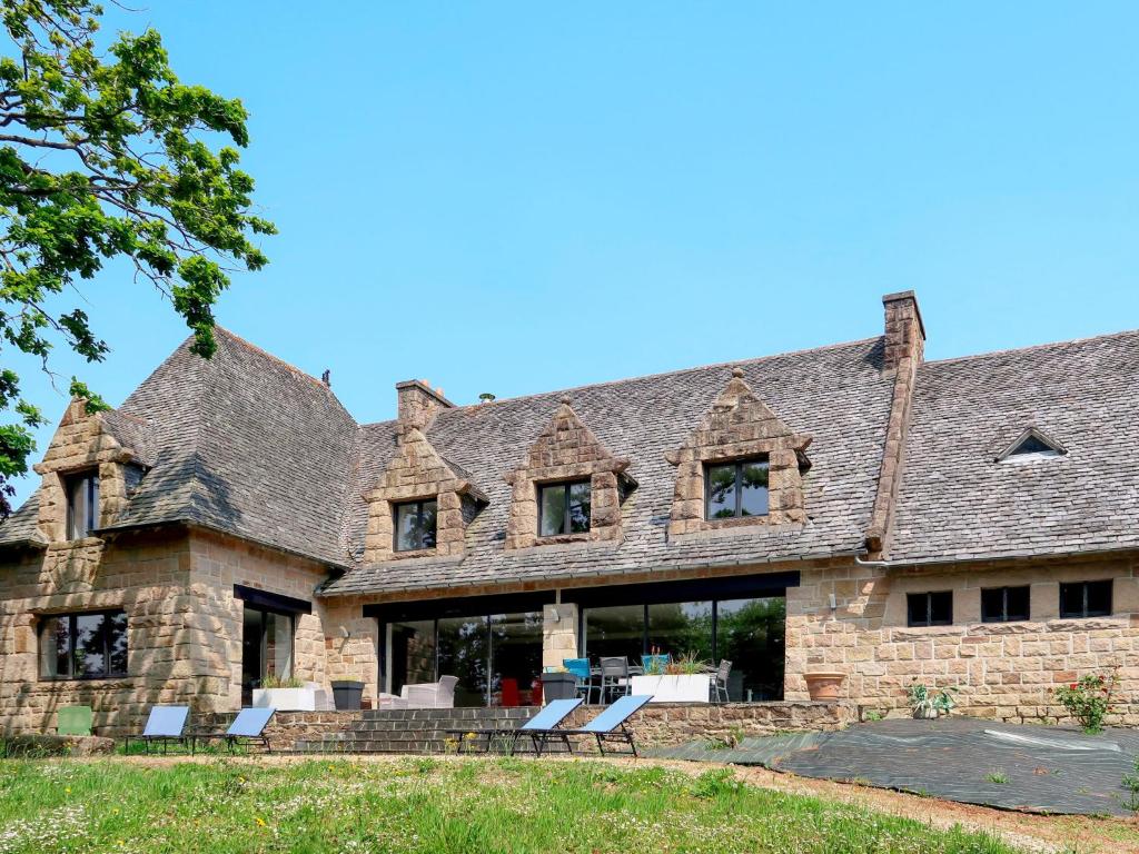 ein großes Steinhaus mit einem Dach mit Fenstern in der Unterkunft Villa La Boissière - MLX200 by Interhome in Morlaix
