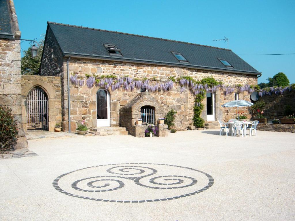 een stenen gebouw met een spiraalvormig ontwerp op de grond bij Holiday Home Gîte Triskell - PML101 by Interhome in Ploumilliau