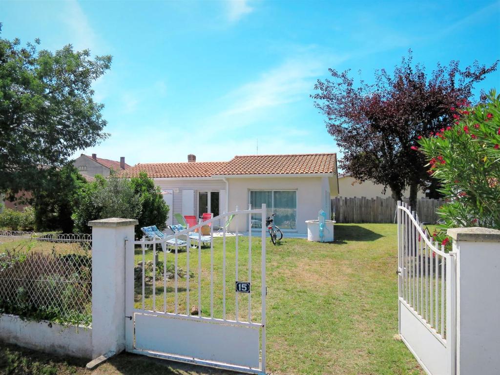 a white fence in front of a house at Holiday Home Mon Poussin - SVV120 by Interhome in Saint-Vivien-de-Médoc