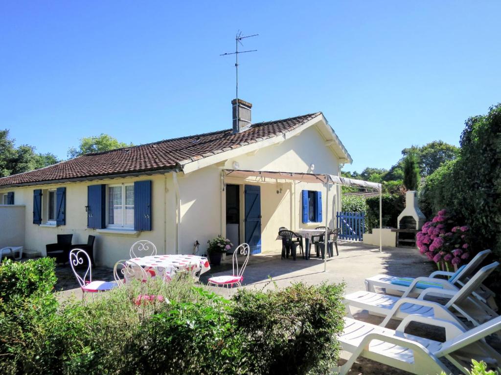 a house with a patio with chairs and a table at Holiday Home Pontac-Gadet 1 - JDL100 by Interhome in Jau-Dignac-et-Loirac