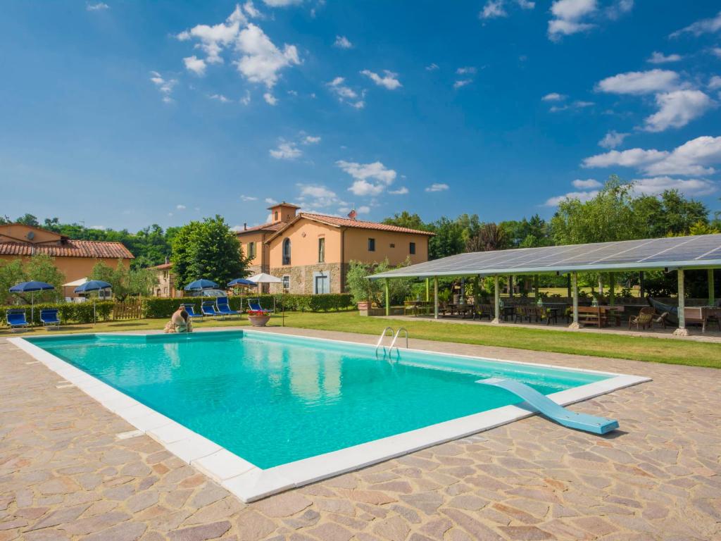 una piscina in un cortile con una casa di Apartment Azalea by Interhome a Pian di Scò