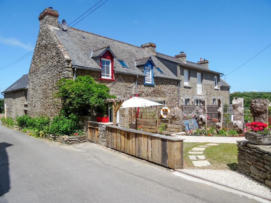 une maison en pierre avec un parasol dans une rue dans l'établissement Holiday Home La Pailloussette - A, à Cancale