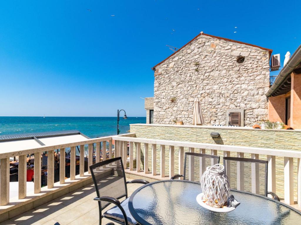 stół i krzesła na balkonie z widokiem na ocean w obiekcie Apartment Antonella & Napoletano-3 by Interhome w mieście Umag