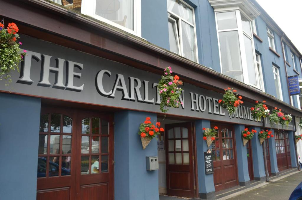 a building with flowers on the front of a building at The Mumbles Carlton Hotel in The Mumbles