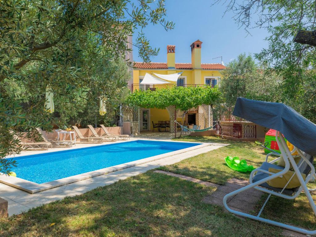 um quintal com uma piscina e uma casa em Holiday Home Duje & Mare - Mdn184 by Interhome em Ližnjan