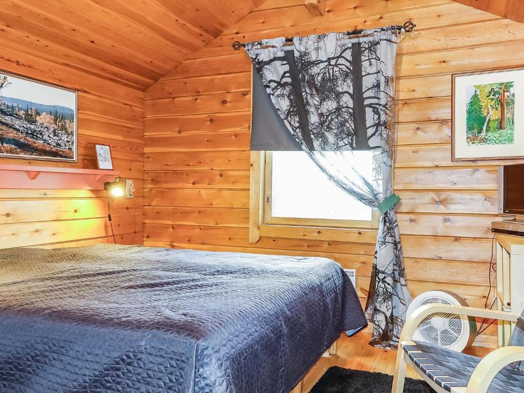 a bedroom with a bed in a wooden cabin at Holiday Home Sallanrinne b by Interhome in Salla