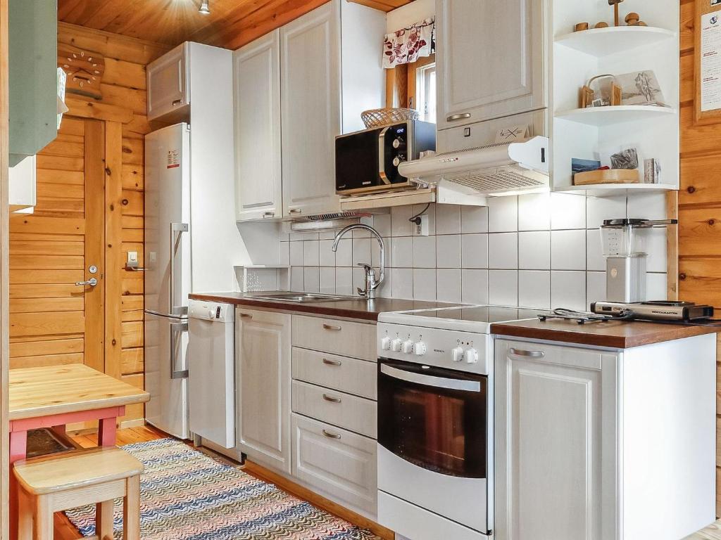a kitchen with white cabinets and a stove top oven at Holiday Home Sallanrinne b by Interhome in Salla