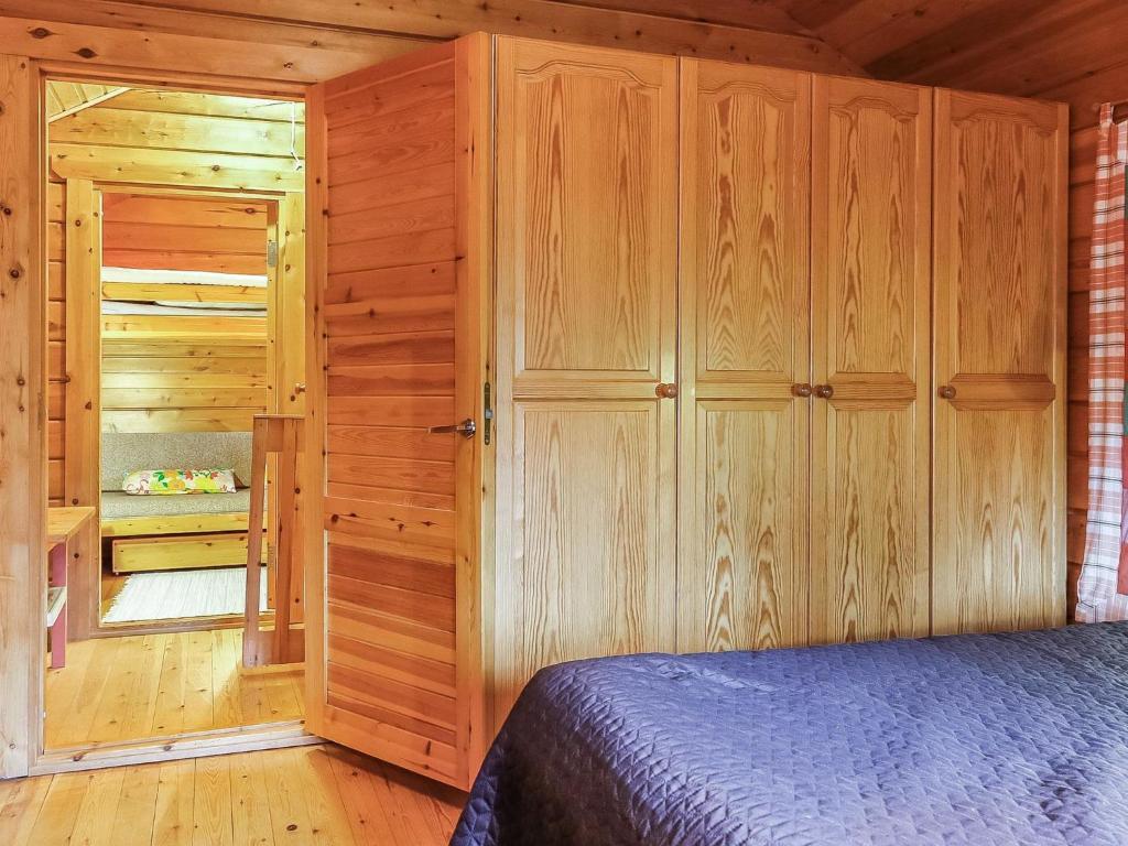 a bedroom with wooden walls and a bed in a cabin at Holiday Home Sallanrinne b by Interhome in Salla