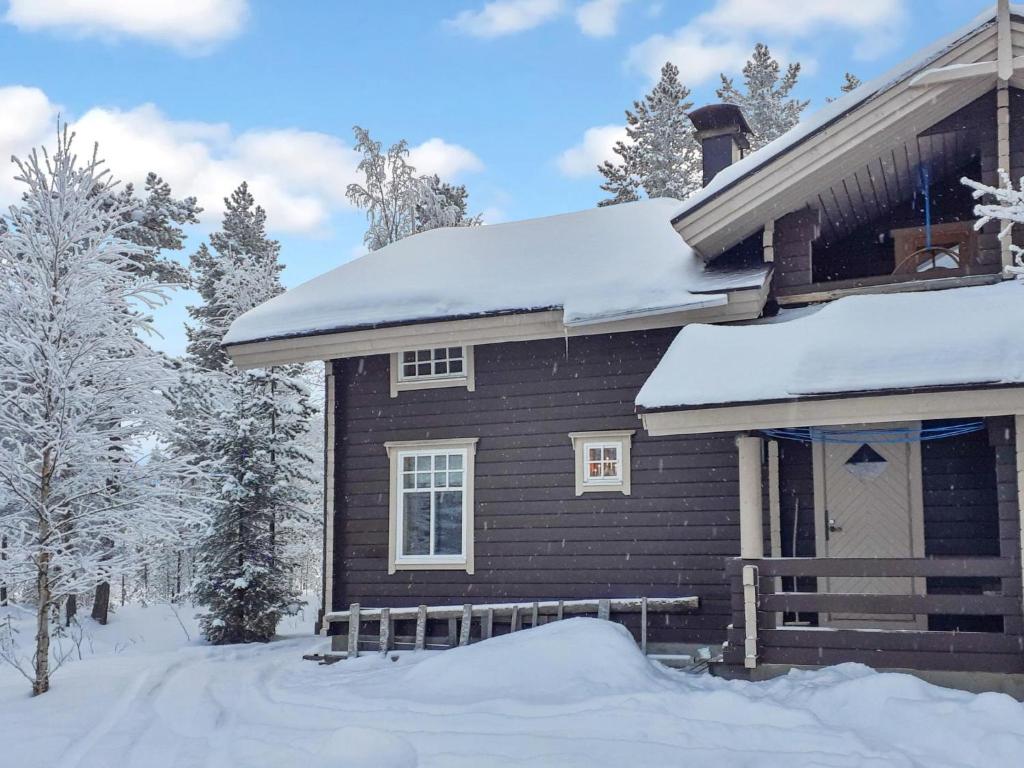 a wooden house with snow on the roof at Holiday Home Sallanrinne b by Interhome in Salla