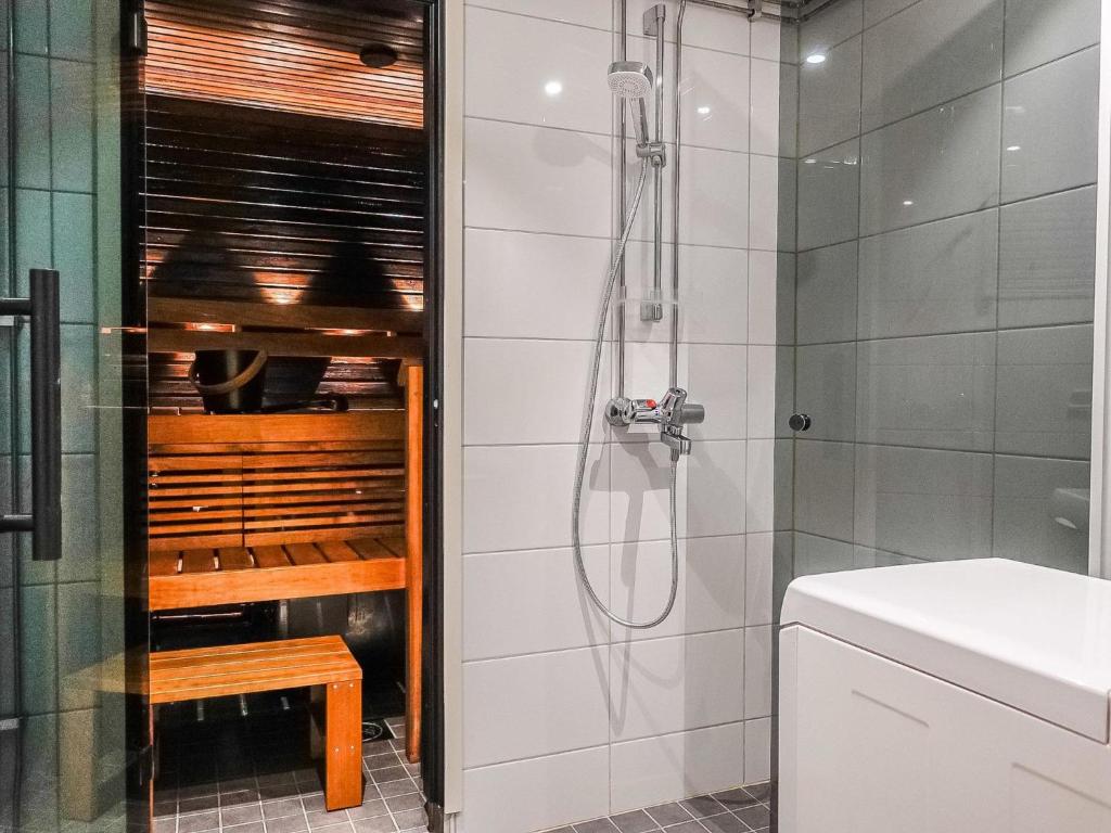 a bathroom with a shower and a bench in it at Holiday Home Sallanrinne b by Interhome in Salla