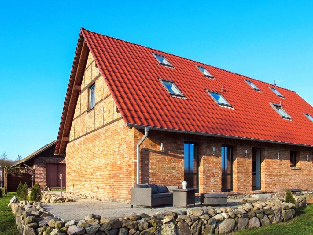 een stenen huis met een rood dak bij Apartment zum Katzengrund II by Interhome in Hinrichshagen