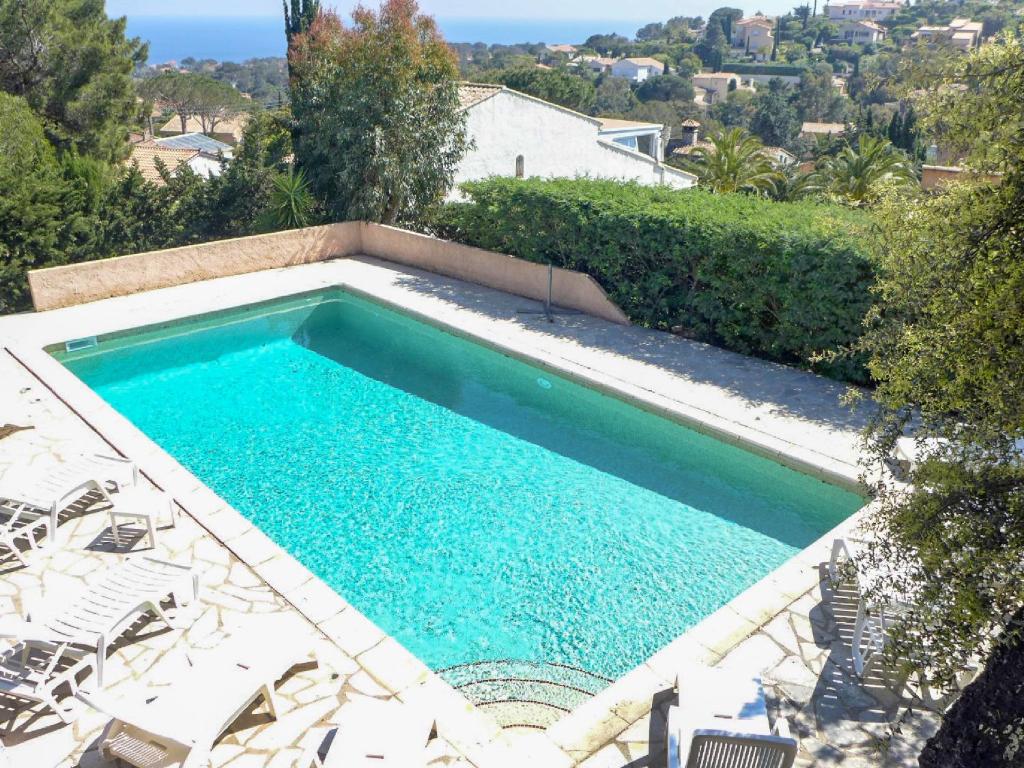 a swimming pool in a yard with chairs and trees at Villa La Galandière by Interhome in Saint-Aygulf