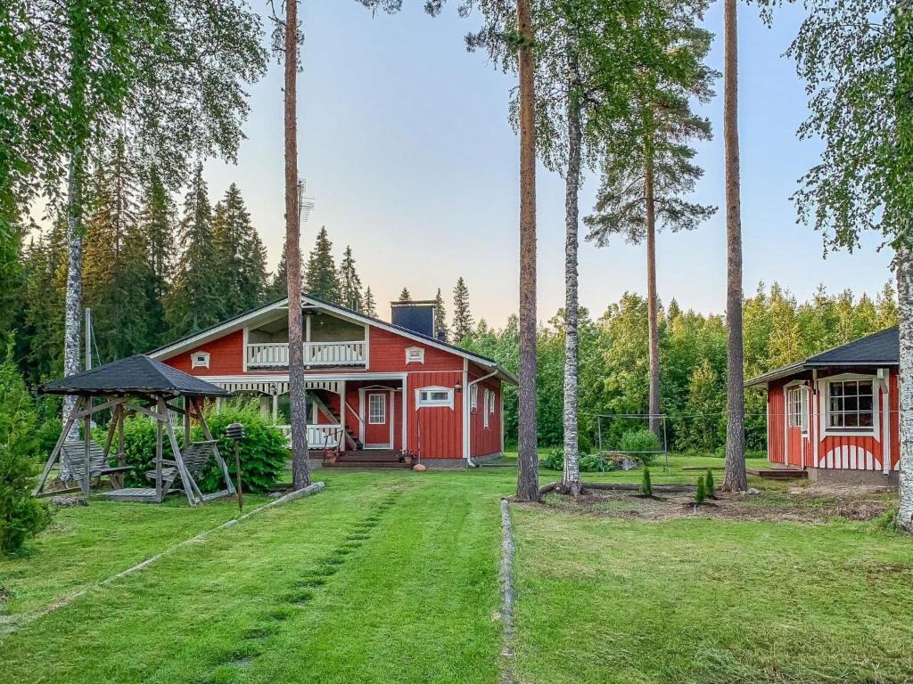 une grange rouge avec des arbres devant une cour dans l'établissement Holiday Home Majavanpesä by Interhome, à Virtasaari